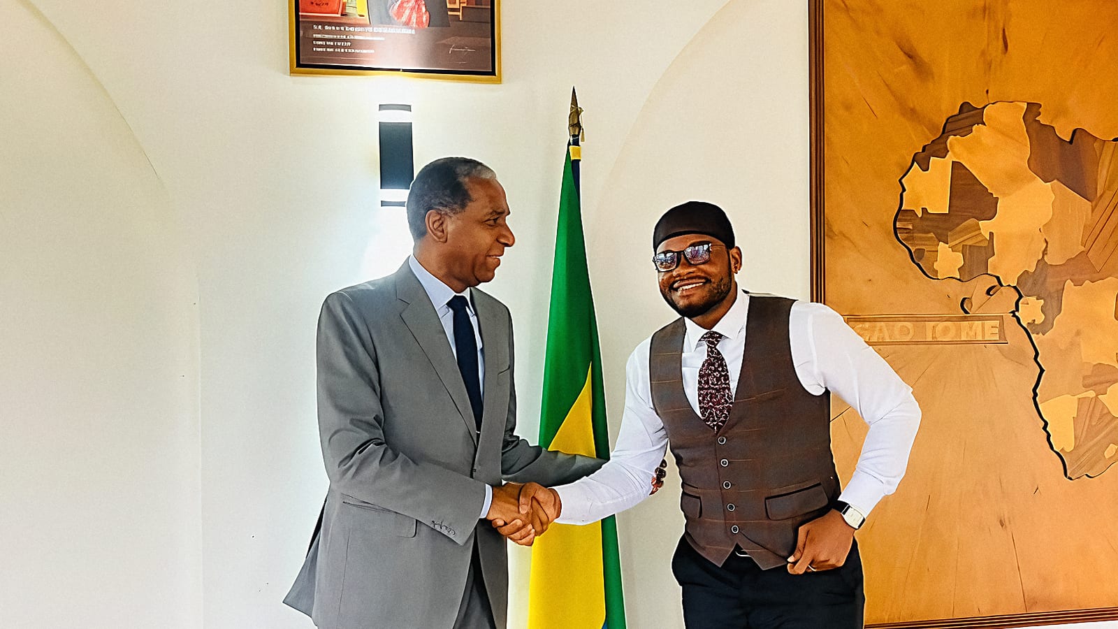 Deux hommes en costume assis dans un bureau diplomatique, drapeaux du Gabon et de Sao Tomé-et-Principe en arrière-plan