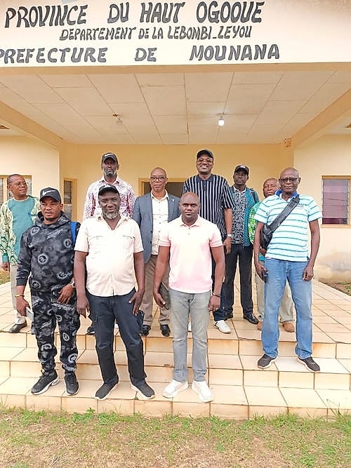 Un homme en costume serre la main d'habitants dans une rue de Mounana, au Gabon