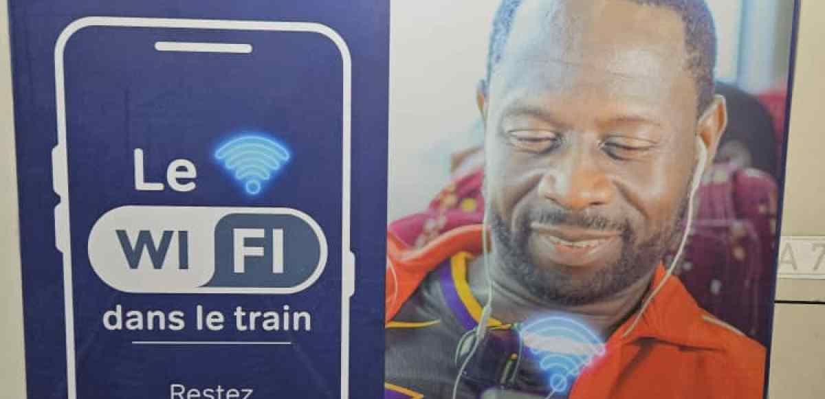 Intérieur d'un wagon de train voyageur avec écran d'information au plafond