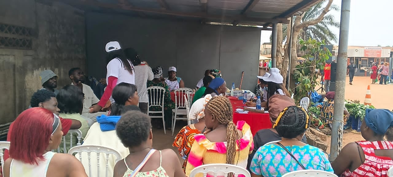 Personnel médical réalisant un test de dépistage du VIH sous une tente dans un marché africain