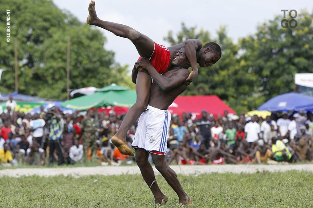 Scène de lutte traditionnelle kabyè avec spectateurs en arrière-plan