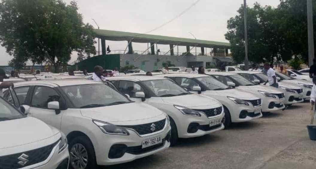 Des taxis neufs alignés devant des officiels lors d'une cérémonie de remise à Port-Gentil