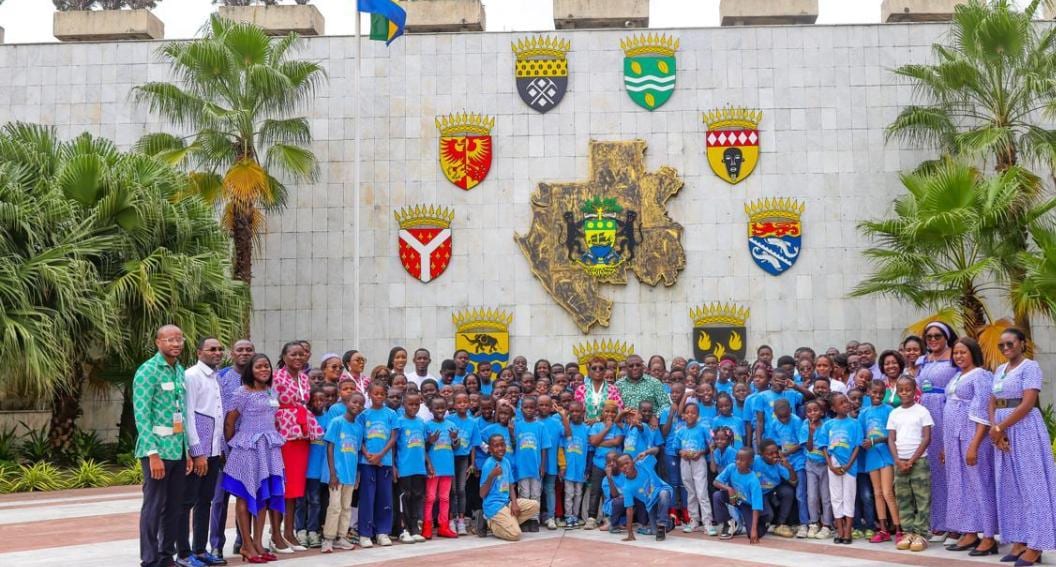 Enfants en visite devant un bâtiment institutionnel à Libreville