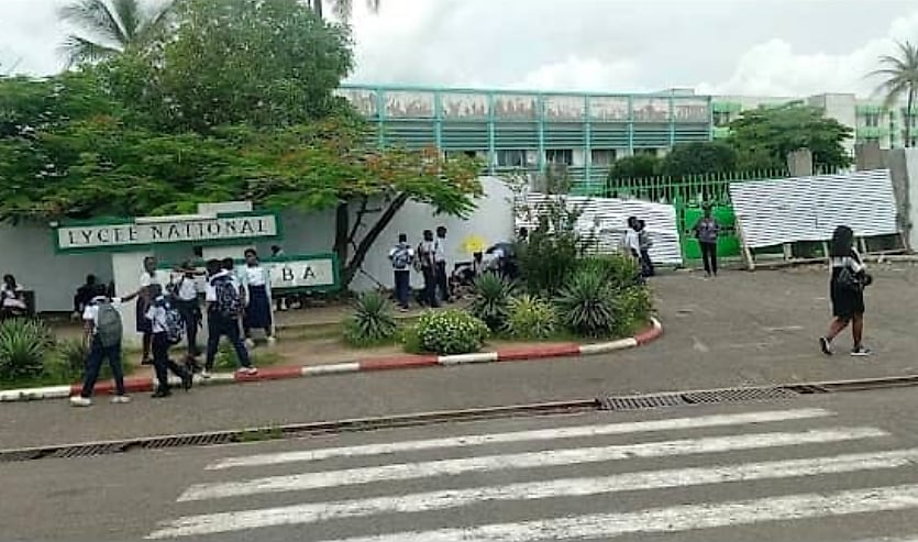 Bâtiment scolaire gabonais avec panneau d'affichage à l'entrée