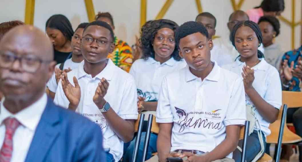 Jeunes bacheliers gabonais tenant des documents devant un bâtiment universitaire