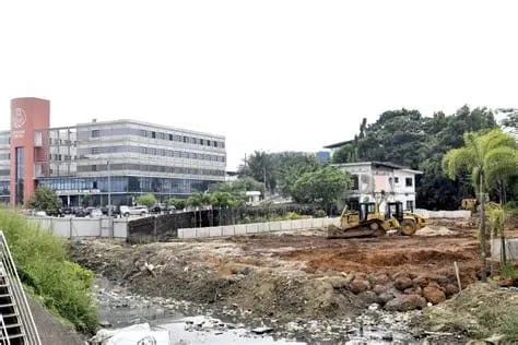 Quartier d'habitations denses au Gabon vu depuis les hauteurs, avec toits de tôle et voies étroites