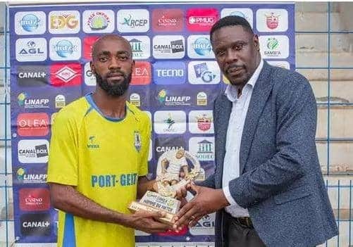 Un footballeur en maillot de club célèbre un but sur un stade au Gabon