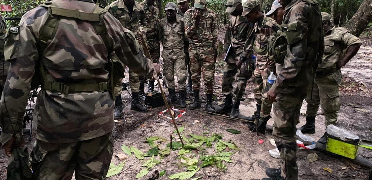 Des militaires en tenue de treillis cultivant un champ à Plaine Ayémé, Ntoum.