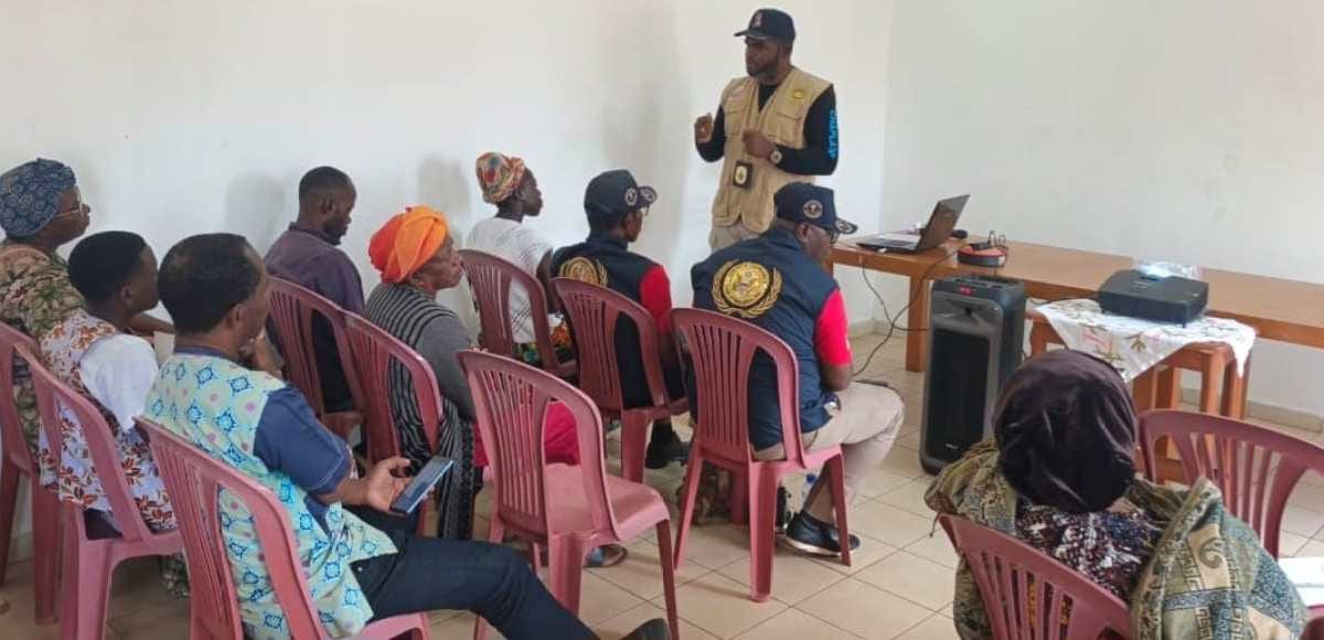 Salle de réunion avec des participants assis, ambiance de sensibilisation communautaire