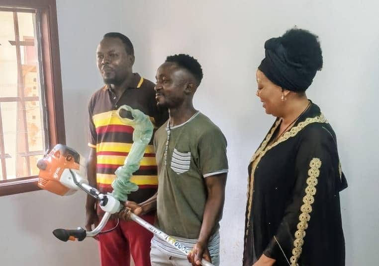 Une élue remet du matériel d'entretien à de jeunes bénéficiaires à Franceville, au Gabon.