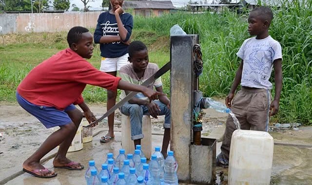Bidons d'eau alignés près d'un robinet dans un quartier populaire de Libreville