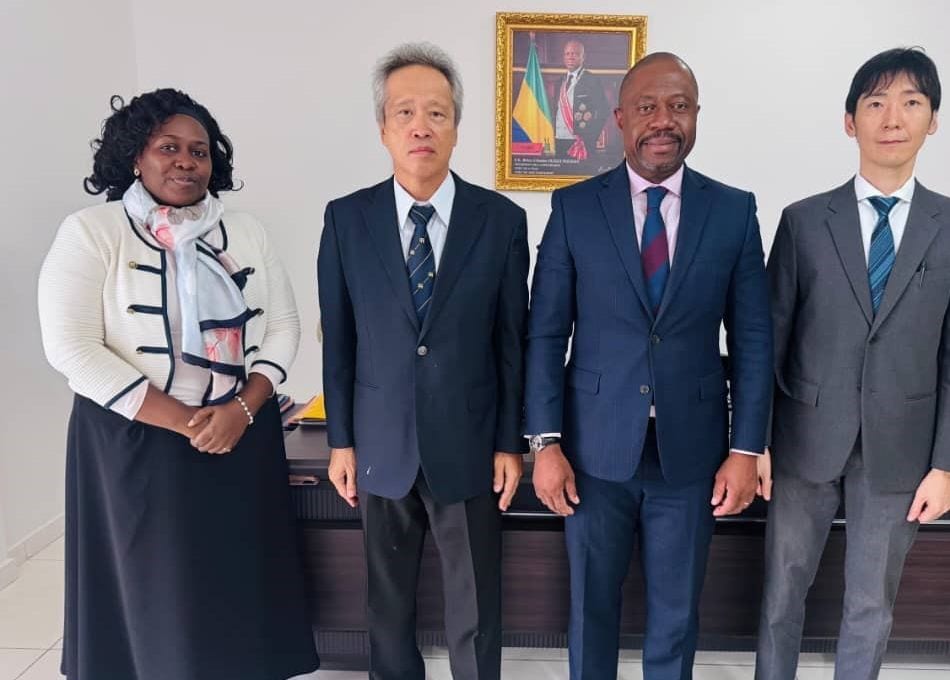 Vue d'un champ agricole au Gabon avec des personnes en discussion