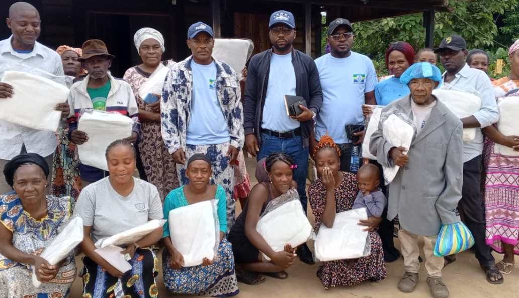 Terrain de sport en plein air avec spectateurs assistant à une compétition dans un district gabonais.