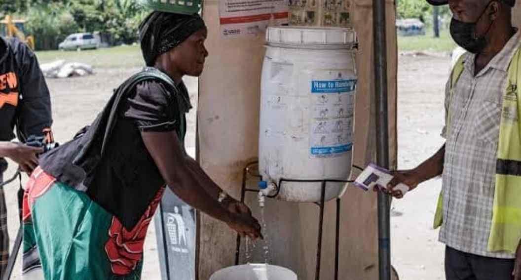 Agents sanitaires en tenue de protection à un poste frontalier