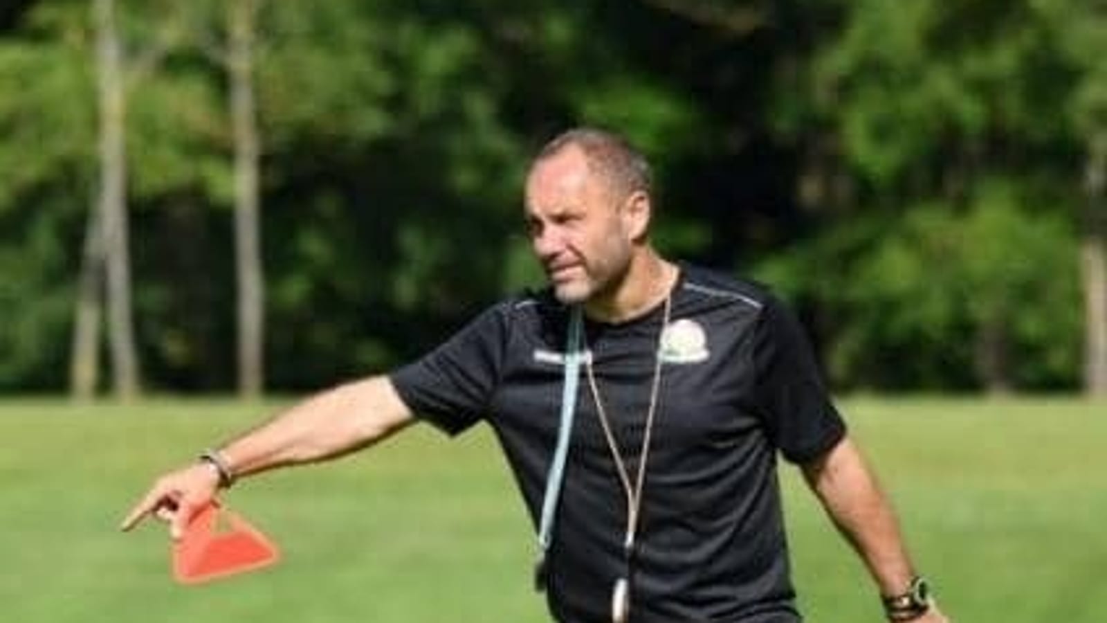 Entraîneur de football donnant des consignes en bord de terrain