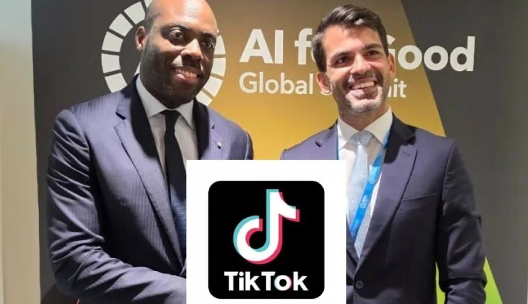 Main tenant un smartphone affichant l'application TikTok, arrière-plan urbain flou.