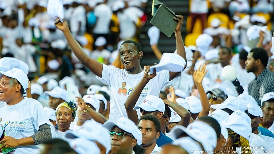 Jeunes gabonais tenant des dossiers de candidature dans une rue de Libreville