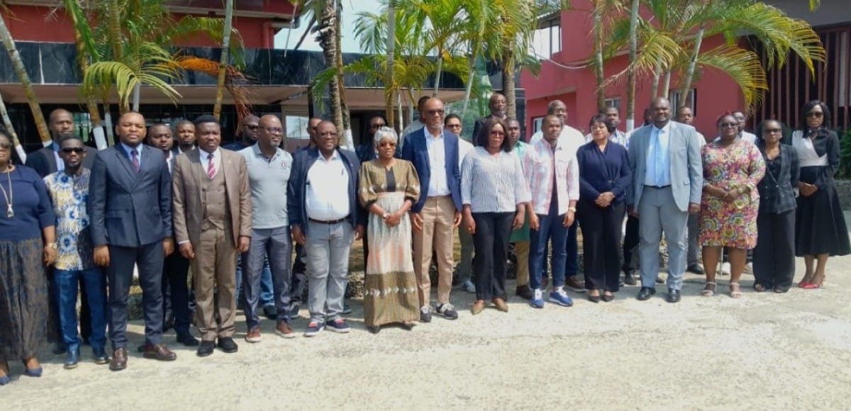 Participants réunis dans une salle d'atelier autour d'écrans présentant des schémas numériques
