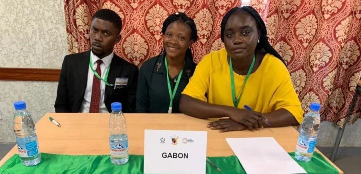 Étudiants en robe d'avocat participant à un concours de plaidoirie dans un amphithéâtre universitaire