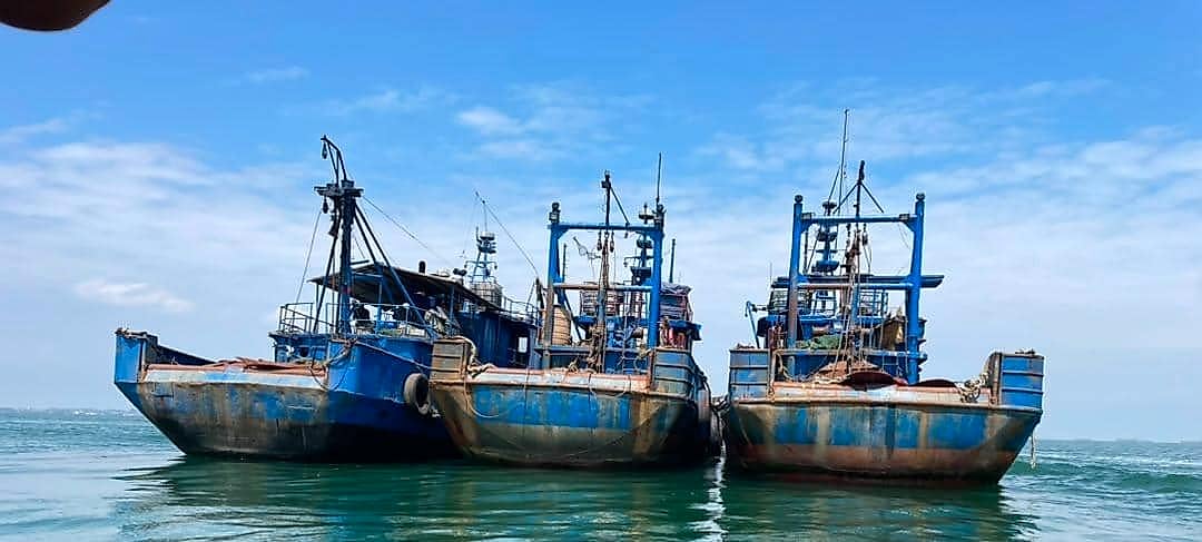 Chalutier de pêche industrielle en mer, escorté par une vedette de surveillance maritime au large des côtes gabonaises