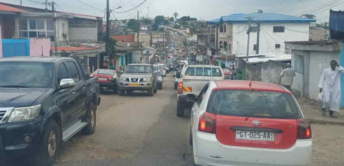 Trottoir urbain à Libreville avec piétons et commerces ambulants