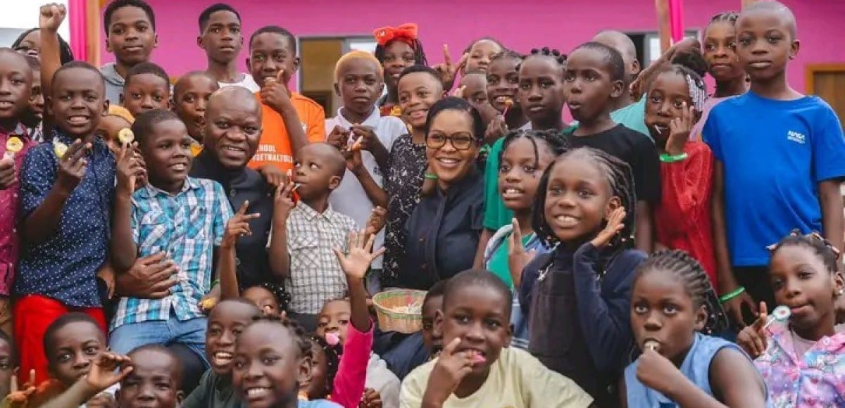 Enfants souriants participant à une activité collective en plein air dans le cadre d'un camp de vacances.