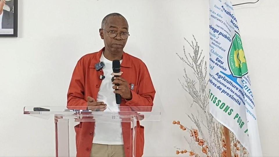 Homme en costume s'exprimant devant un pupitre lors d'une conférence de presse