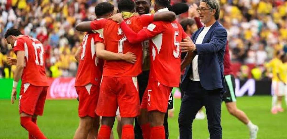 Stade de football américain reconverti pour un match international, avec drapeaux argentin et suisse.