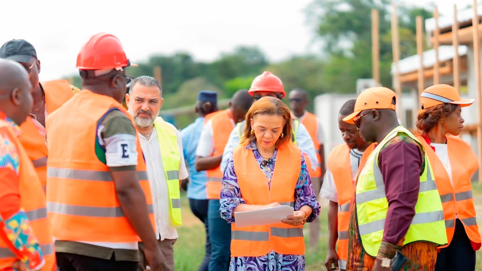 Chantier de construction d'un centre médical avec échafaudages et ouvriers