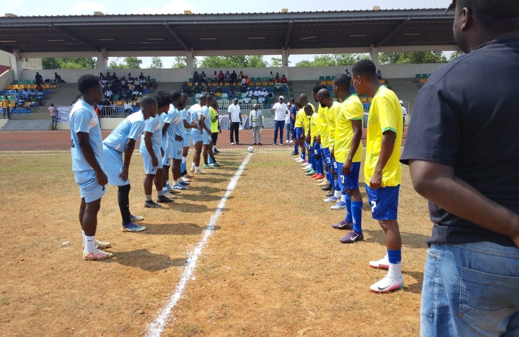 Terrain de football du CIMFEP à Nkok avec joueurs alignés pour le coup d'envoi