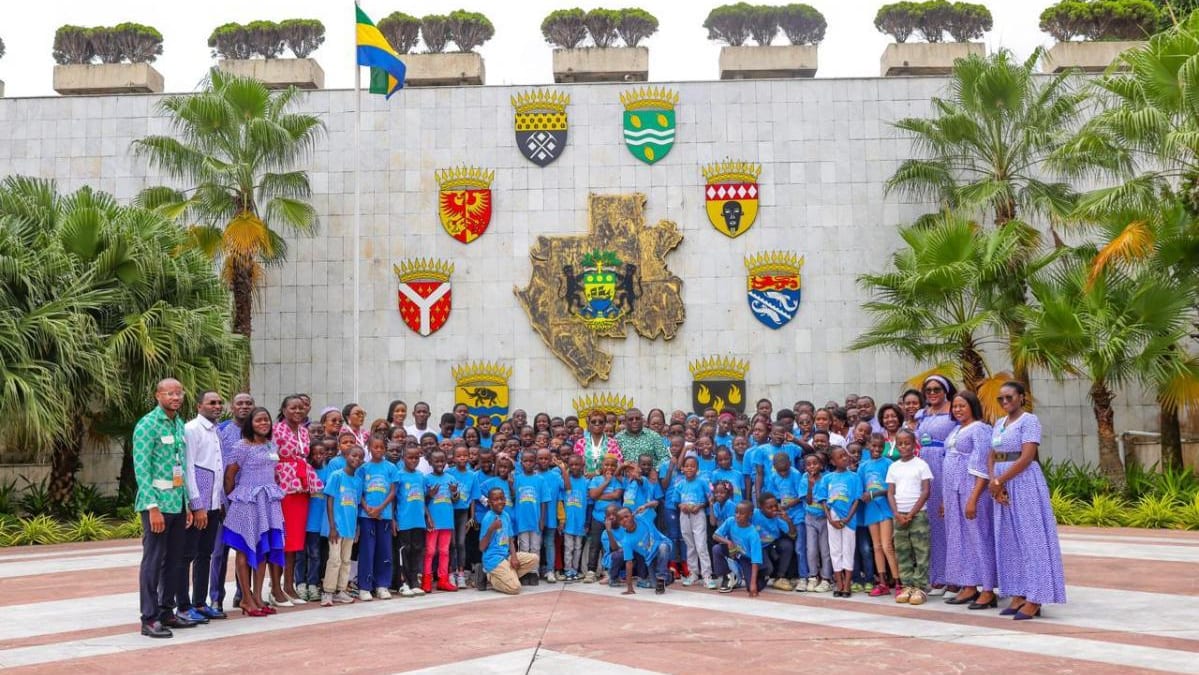 Enfants en visite devant un bâtiment institutionnel à Libreville