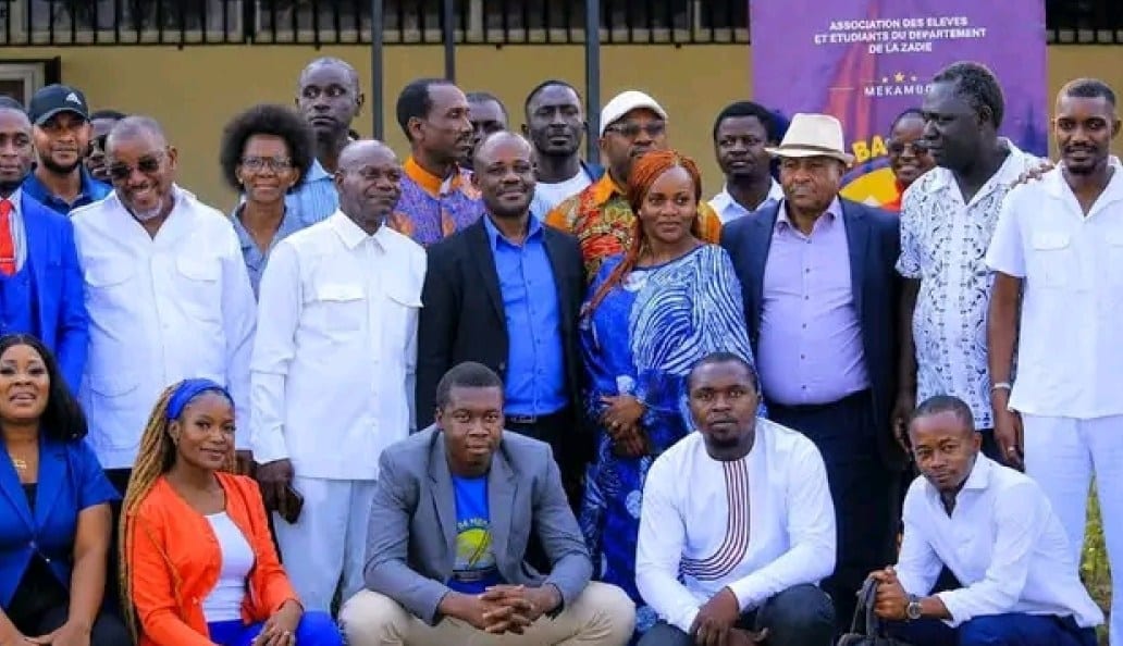 Public varié assis dans un amphithéâtre universitaire lors d'un colloque sur les traditions gabonaises