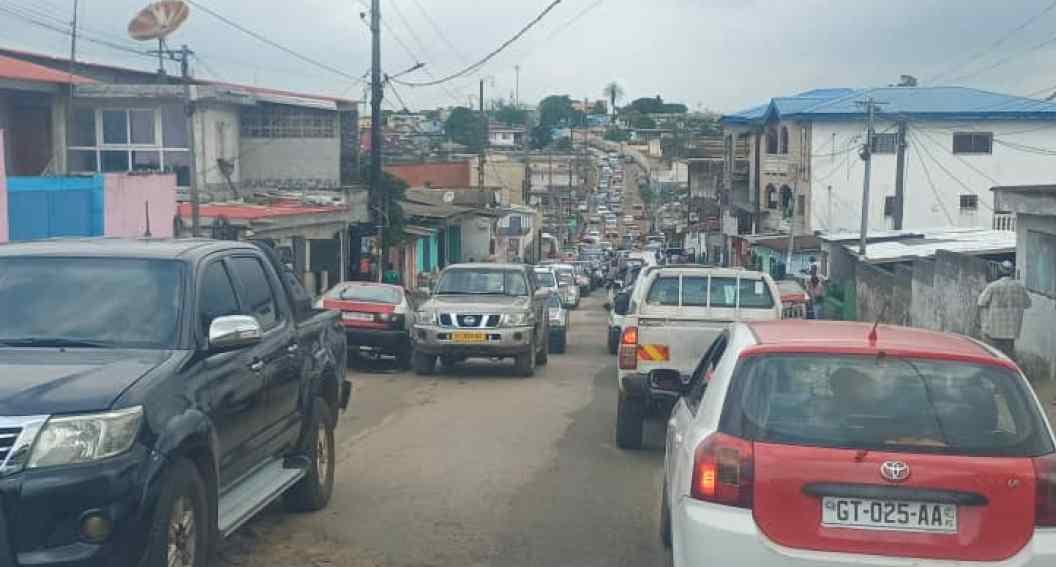 Trottoir encombré par des étals de vente à Libreville, piétons marchant sur la route