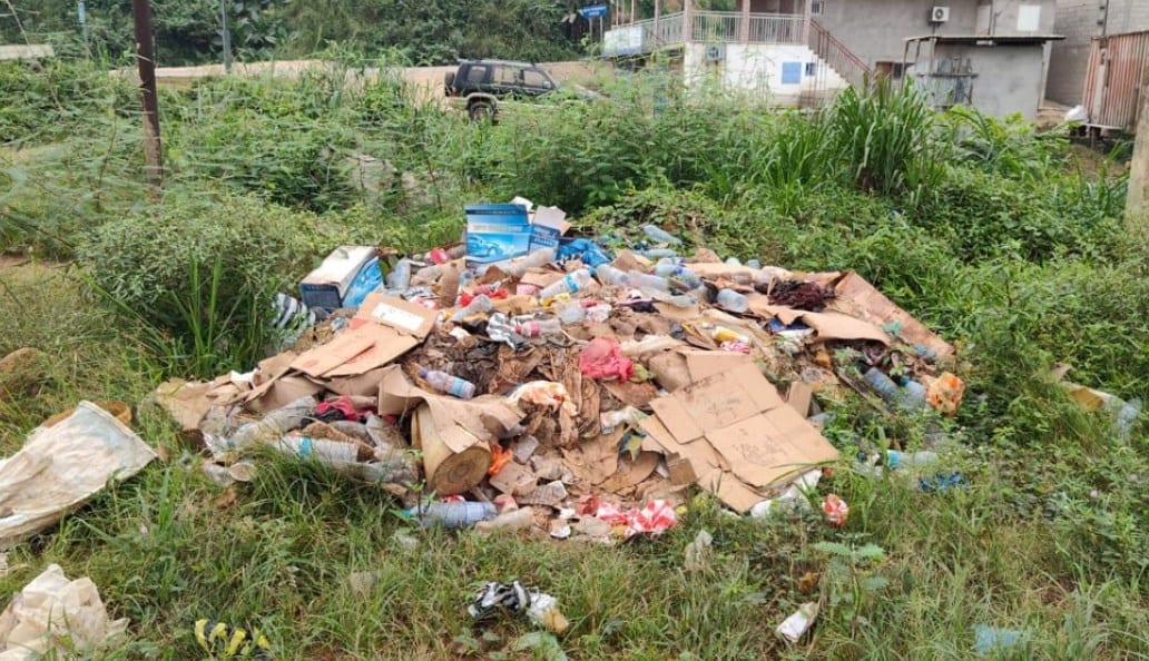 Flaque d'eau stagnante et déchets au bord d'une route en zone urbaine gabonaise