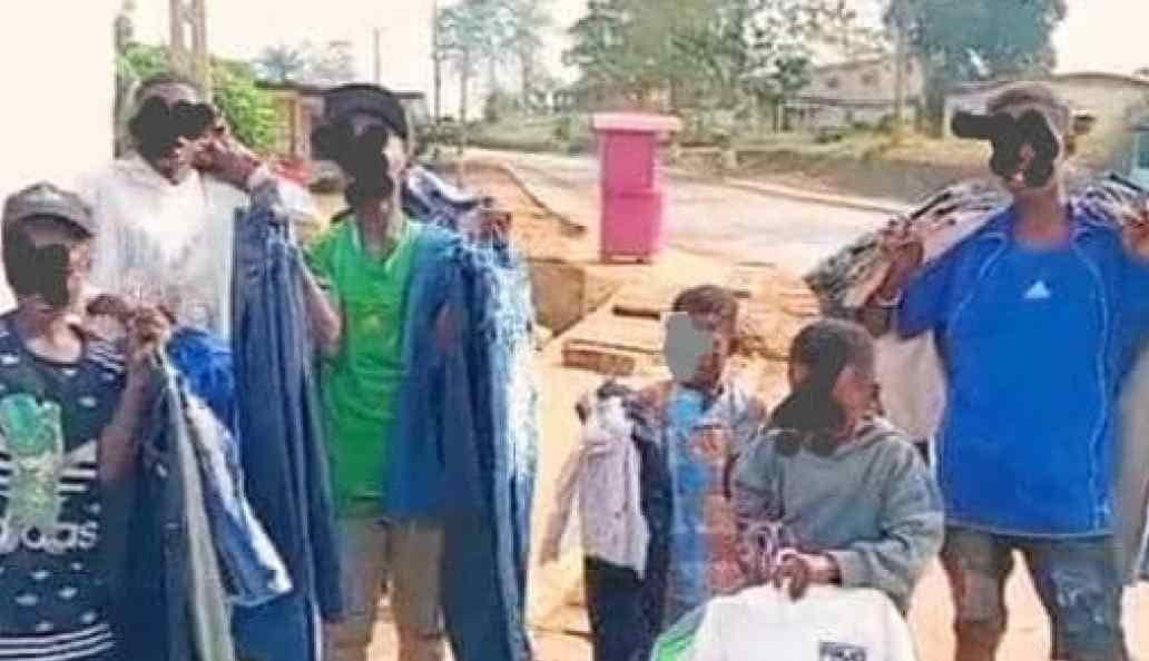 Deux jeunes vendeurs proposant des vêtements de seconde main dans une rue de Tchibanga, au Gabon.