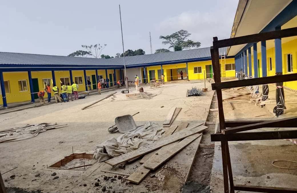 Bâtiment scolaire en fin de construction, façade claire, quelques échafaudages encore visibles