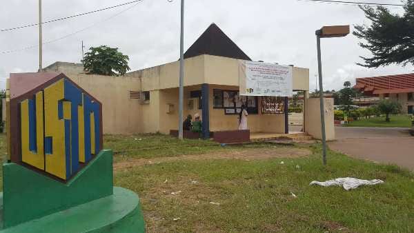 Bâtiment universitaire au Gabon avec des étudiants aux abords
