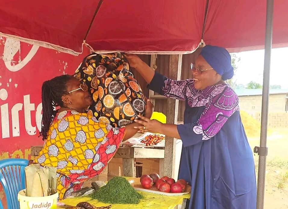 Sénatrice gabonaise échangeant avec des femmes entrepreneures dans une rue de Franceville
