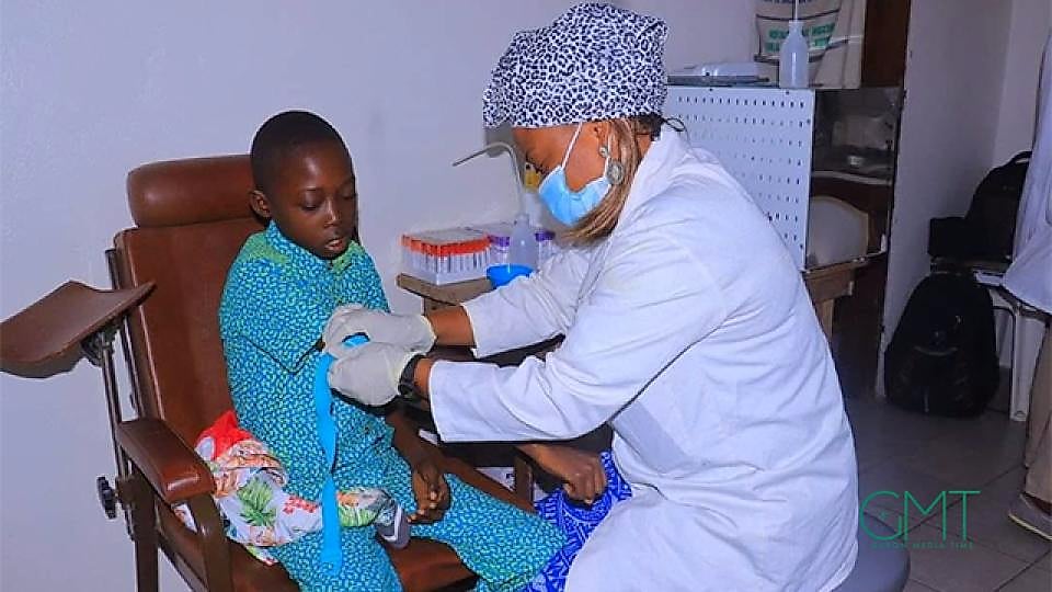 Main d'un soignant effectuant un prélèvement sanguin sur le talon d'un bébé