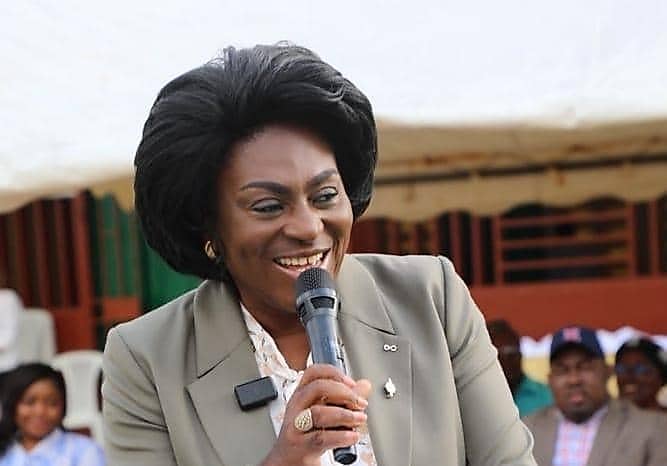 Une femme s'exprime devant un public assis, dans une salle de réunion à Libreville.