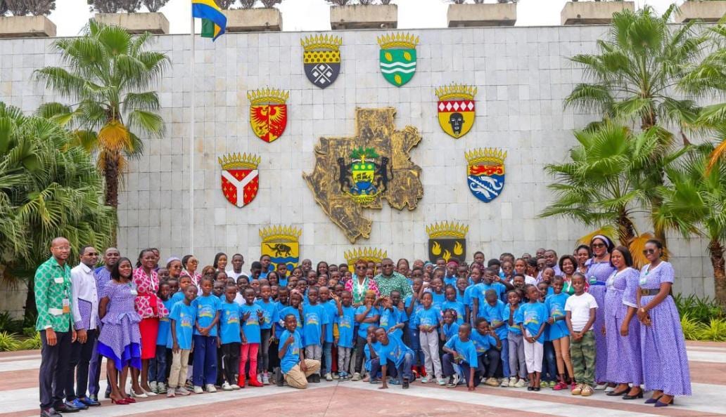 Des enfants en visite devant un bâtiment institutionnel à Libreville.