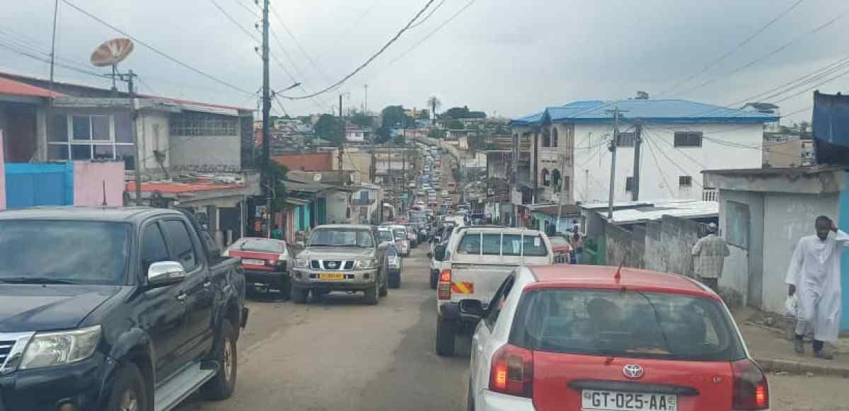 Trottoir encombré à Libreville avec des piétons marchant sur la route faute d'espace