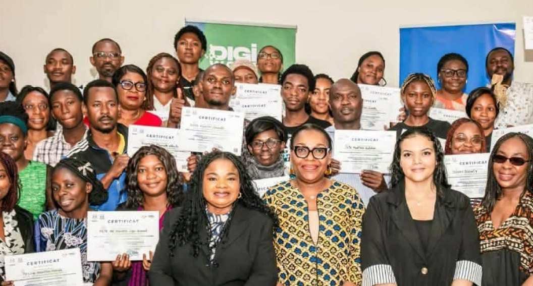Groupe de participants suivant une formation numérique sur ordinateurs dans une salle de classe