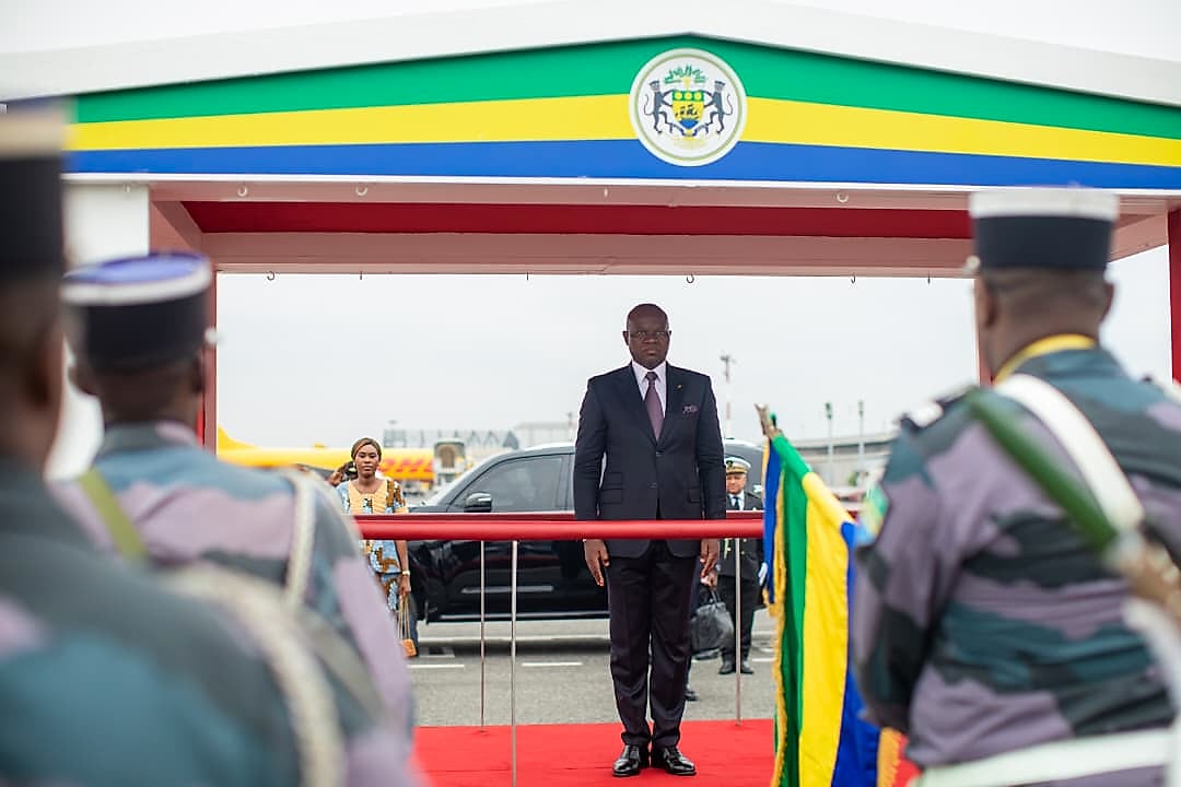 Personnel médical et familles rassemblés devant un dispensaire rural au Gabon