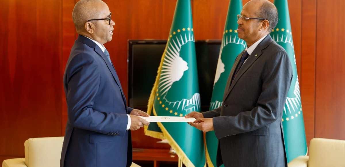 Deux diplomates se serrant la main devant des drapeaux de l'Union africaine