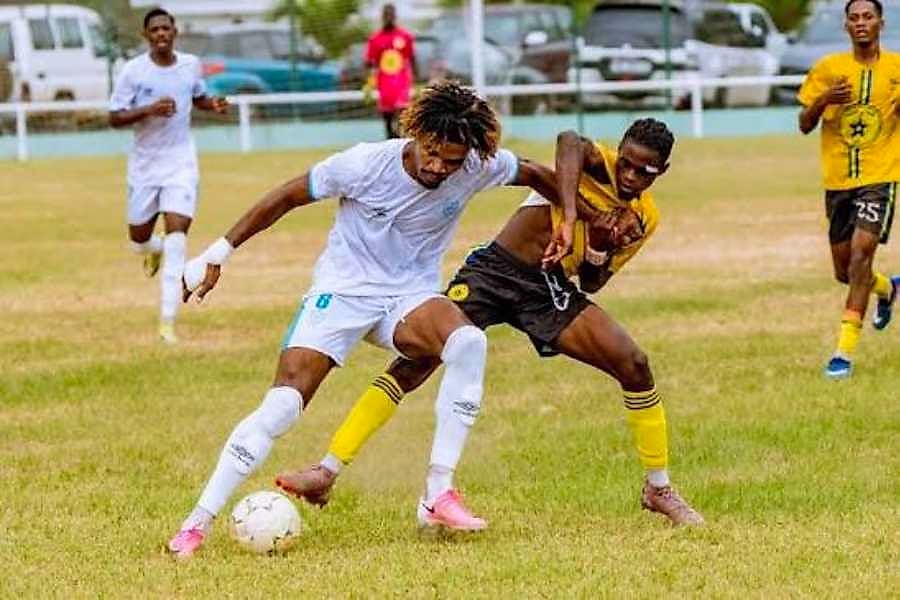Défenseur de football en action sur un terrain, maillot de club gabonais
