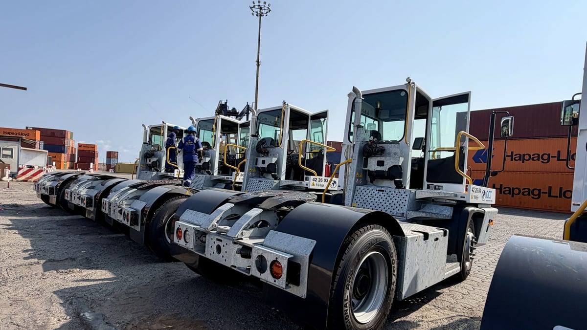 Tracteur portuaire jaune déplaçant un conteneur sur le quai du port d'Owendo