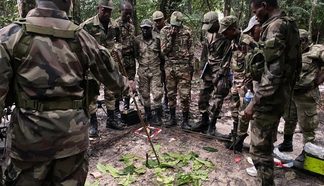 Militaires en tenue de treillis cultivant un champ à Plaine Ayémé, dans la commune de Ntoum