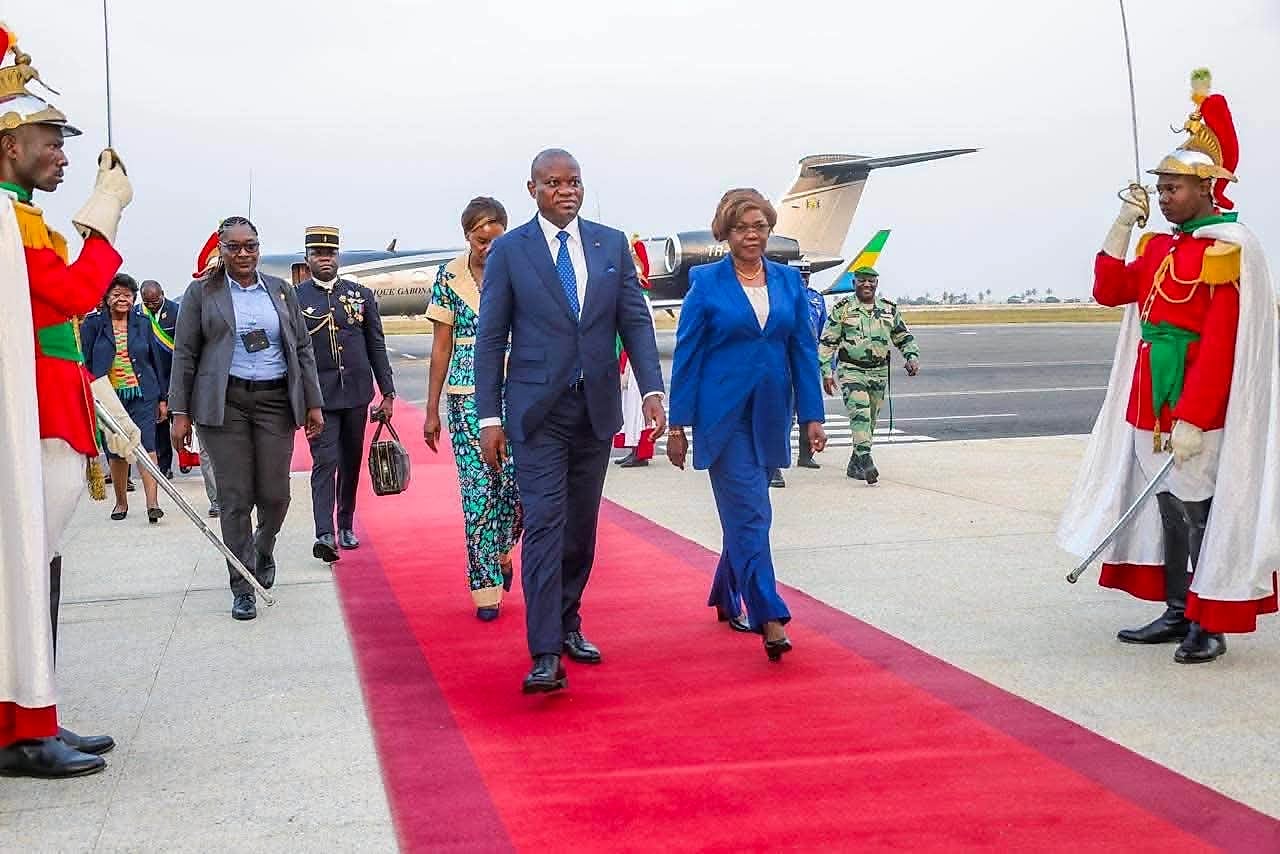 Couple présidentiel gabonais descendant d'un avion officiel, accueilli par des officiels ivoiriens