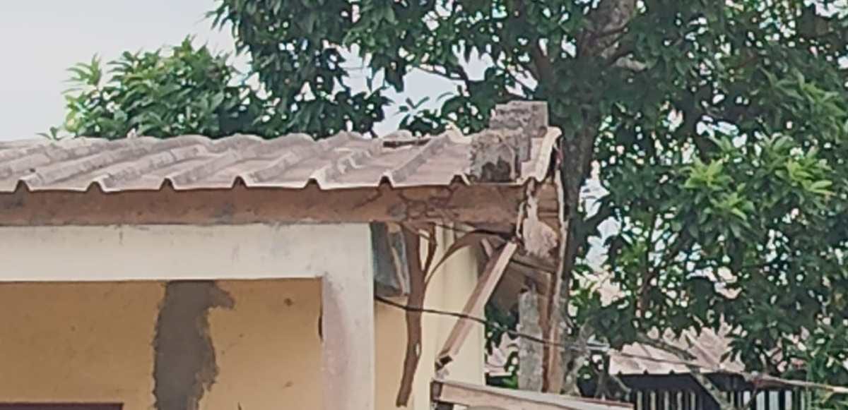 Entrée d'un établissement scolaire au Gabon avec panneau et devise visible.
